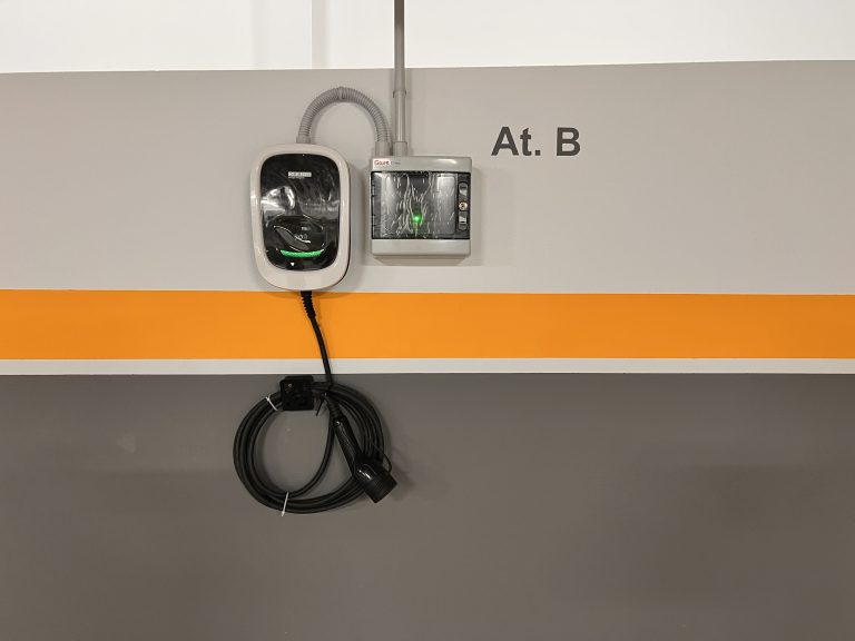 Cargador para coche eléctrico instalado en la plaza de garaje del alojamiento.