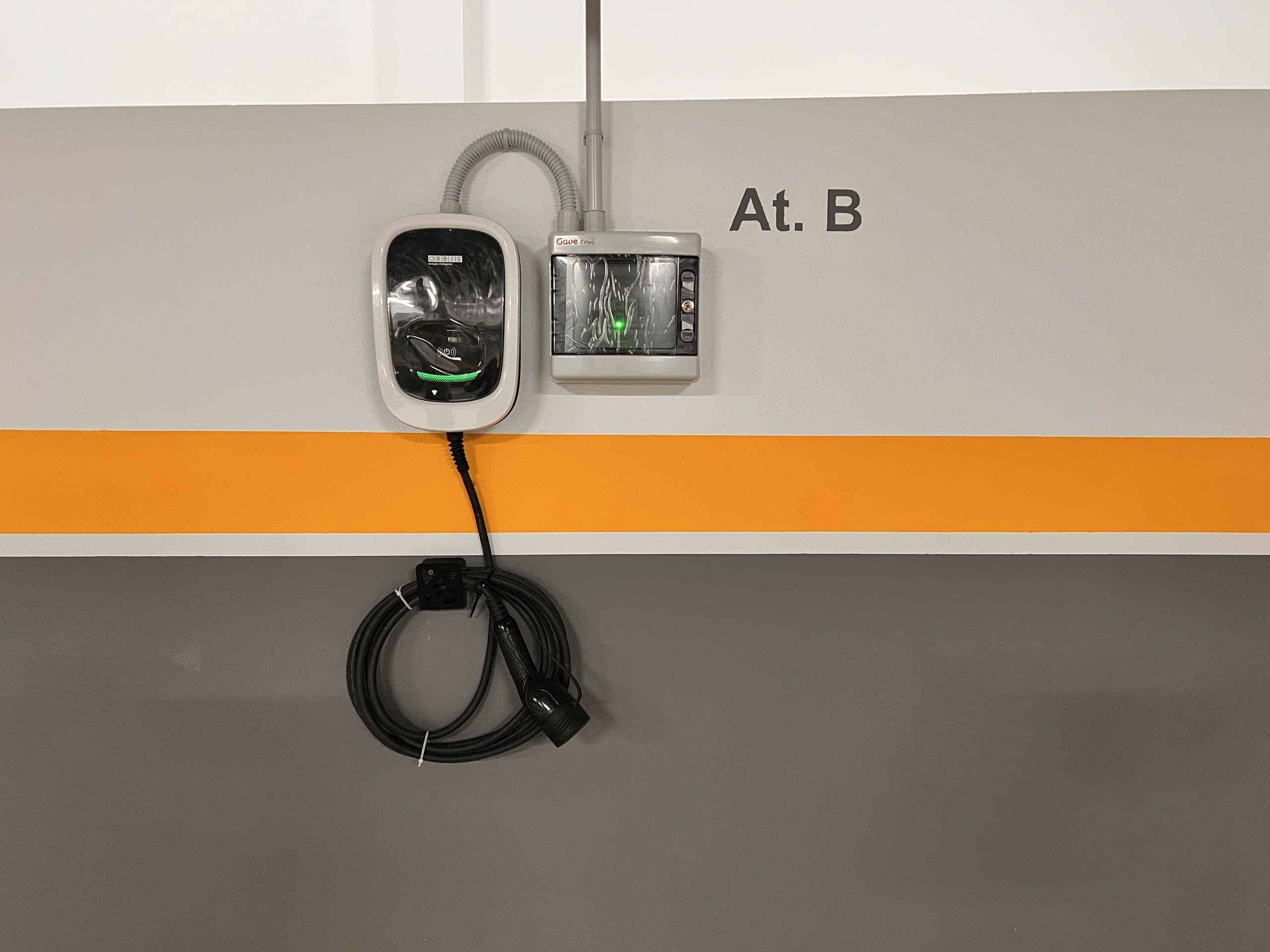 Cargador para coche eléctrico instalado en la plaza de garaje del alojamiento.