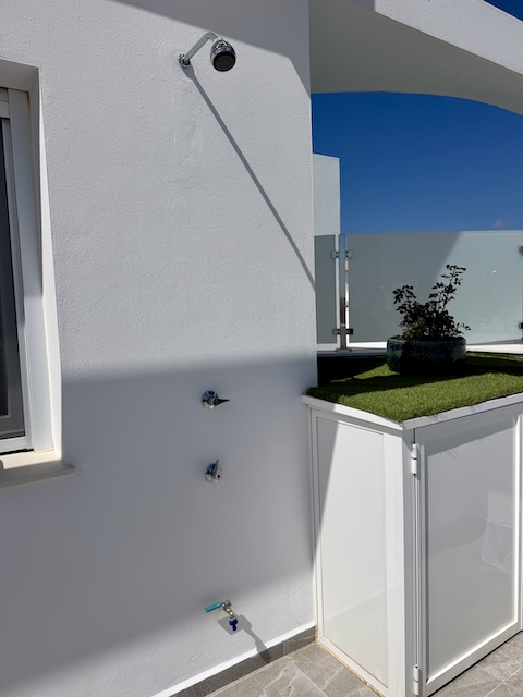 Detalle de ducha exterior junto a la zona de piscina en ático vacacional de Vejer