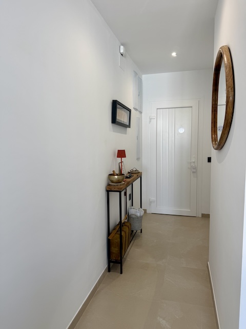 Entrada de ático suite en Vejer de la Frontera con consola decorativa y espejo