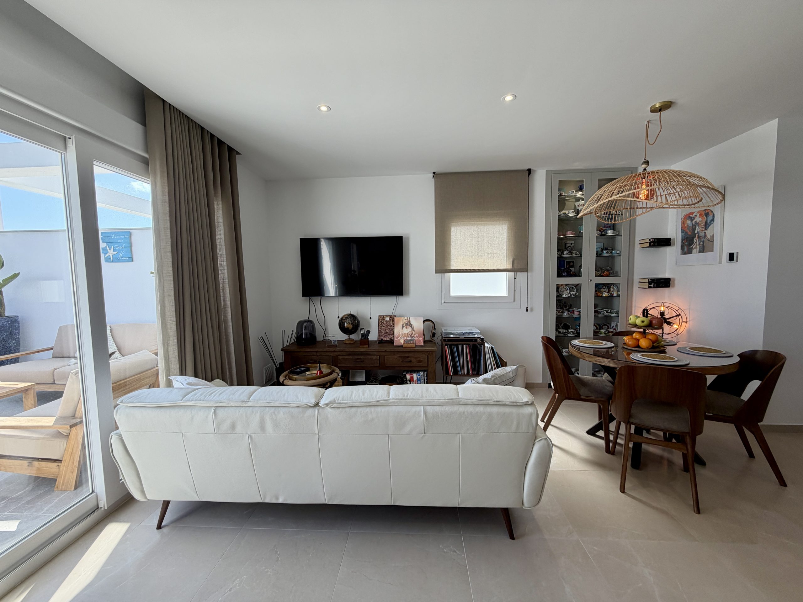 Salón comedor con sofá y acceso a terraza privada en ático vacacional en Vejer