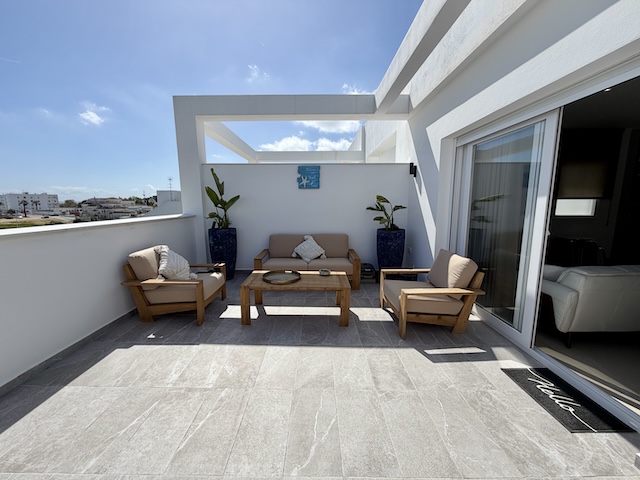 Terraza de ático vacacional con sofá y sillones exteriores en Vejer de la Frontera