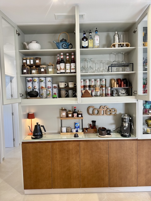 Vitrina abierta del desayunador con café, copas y accesorios en ático suite de Vejer